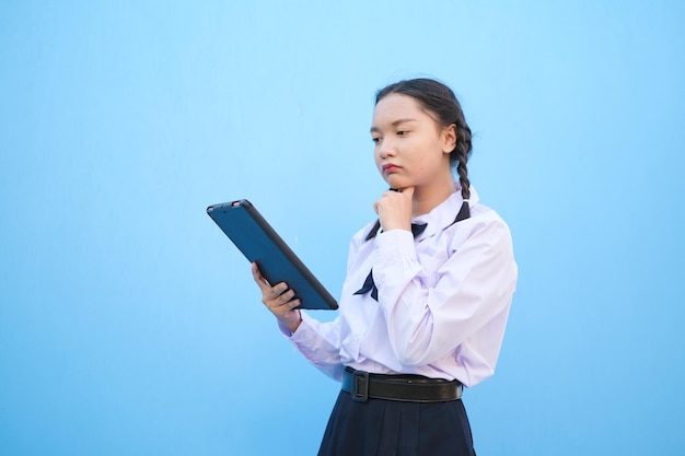 Schoolmeisje met tablet op blauwe achtergrond