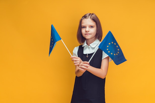 Schoolmeisje met twee kleine vlaggen van de europese unie in haar handen onderwijs in europa concept