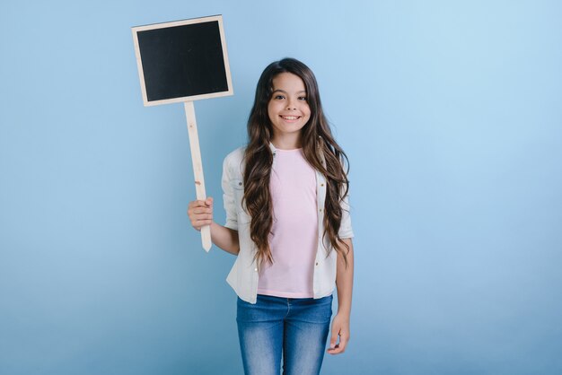 Schoolmeisje staat met een leeg bord in haar handen.