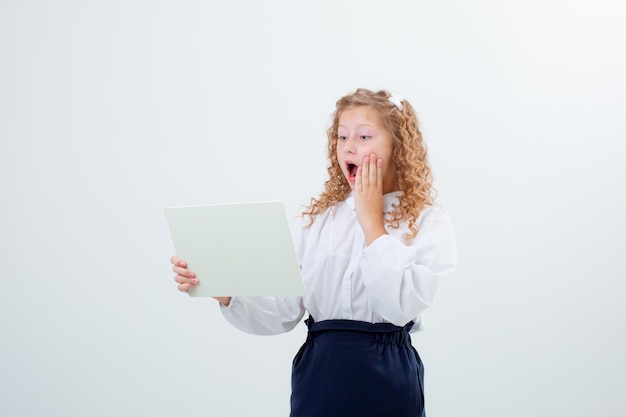 Schoolmeisje tiener meisje in schooluniform met een wit vel papier verrassing op een witte achtergrond