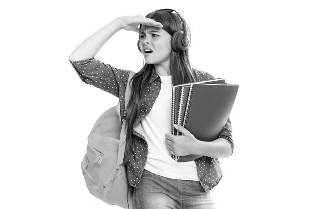 Foto schoolmeisje tiener student levensstijl meisje in koptelefoon houdt boeken op witte geïsoleerde studio achtergrond school en muziek onderwijs concept boze tienermeisje overstuur en ongelukkig negatieve emotie