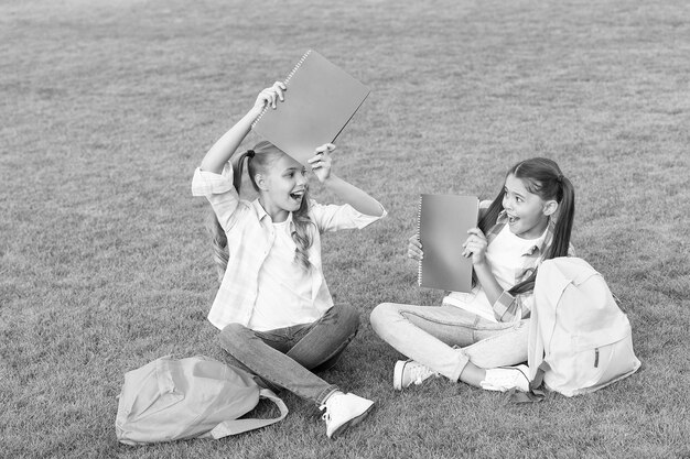 Schoolmeisjes kleine kinderen schoolplein met boeken die taalconcept leren