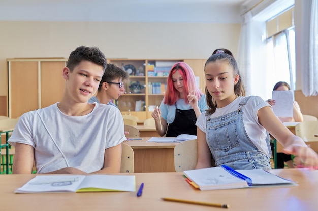 Schoolonderwijs adolescentie Groep tienerkinderen zitten aan bureaus in de klas