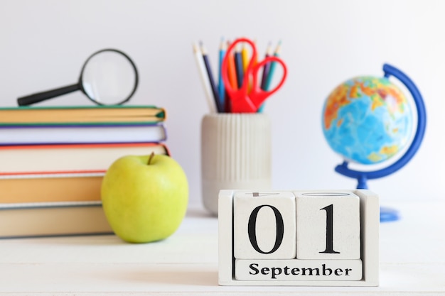 Schoolpapier wereldbol boeken groene appel en kalender gedateerd 1 september Terug naar school