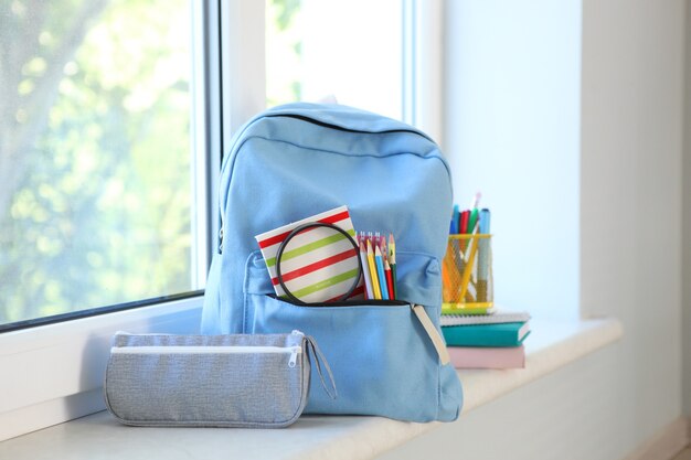 Schoolrugzak en briefpapier in een lichte kamer