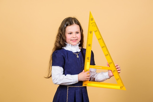 Schoolstudent die meetkunde leert Leerlingmeisje met grote liniaal STEM-schooldisciplines klein meisje terug naar school wiskundeles Onderwijs en kennis Zelfverzekerde afgestudeerde