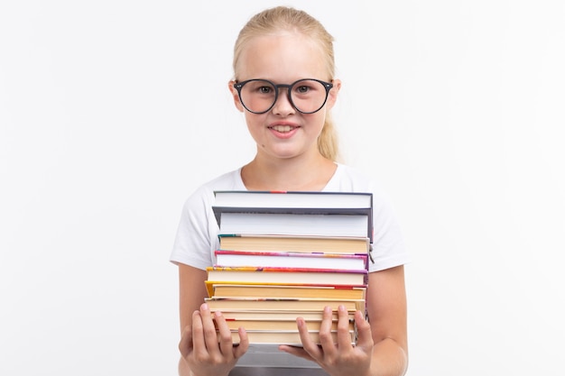 Schoolstudent in beschermende brillen die boeken in handen houden op witte achtergrond