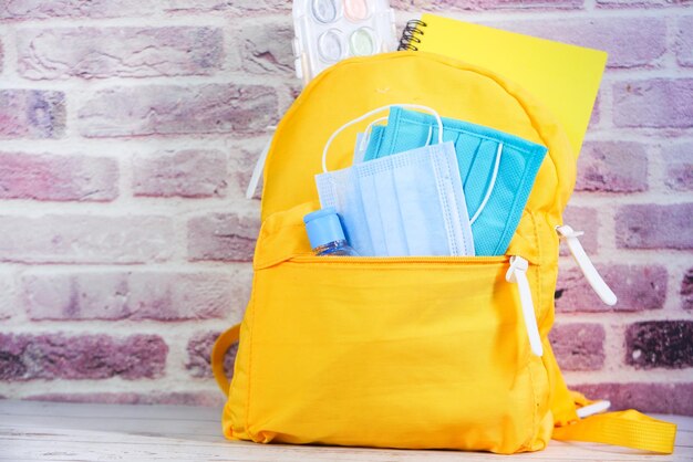 Schooltaspakket voor studenten met ontsmettingsmiddel en gezichtsmasker