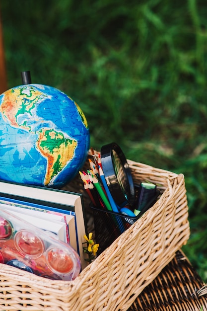 Foto schooluitrusting, boeken en globe in de mand