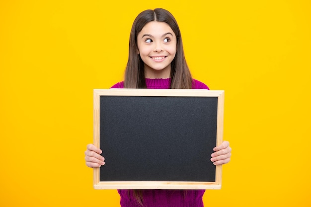 Schoolverkoopbord Vrolijk tienermeisje houdt schoolbord met kopieerruimte vast