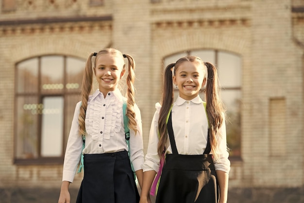 Schoolvrienden Gelukkige vrienden terug naar school Kleine vrienden dragen buiten uniform Mode-look van kleine kinderen School en onderwijs Vriendschapsbanden Relatie Vrienden voor altijd