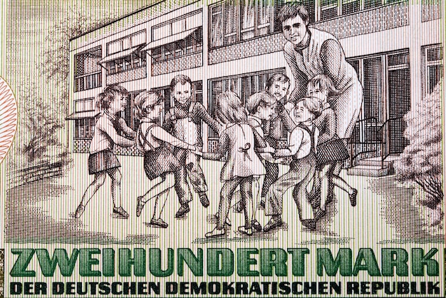 Schoolyard with eight children and a teacher from East German money