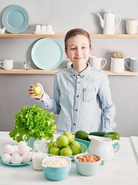 Schoon eten van gezonde kookingrediënten. Frame met voedsel. Superfoods concept. Fitness ontbijt. Gezond eten en eten, dieet, vegetarische keuken, koken concept en gewichtsverlies. Kind jongen in de keuken