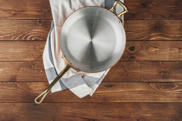 Schoon glanzend koperen keukengerei op een houten bord