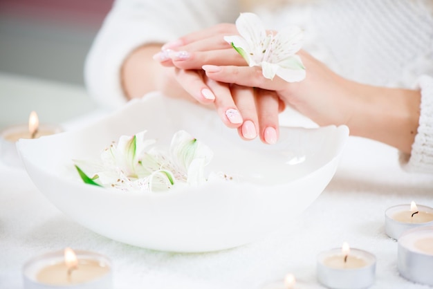 Schoonheid delicate handen met manicure met bloemlelie