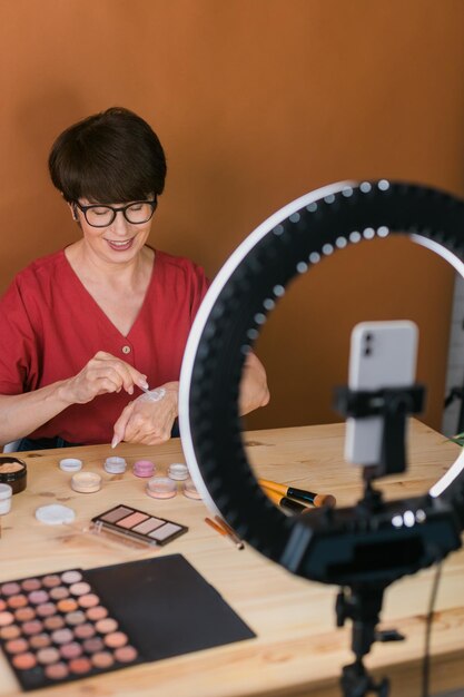 Schoonheid en cosmetica e-commerce en bloggen concept professionele volwassen vrouwelijke make-up artiest testen van nieuwe cosmetica video review opnemen op cosmetische producten thuis