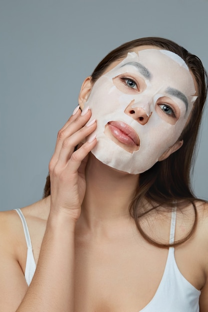 Schoonheid gezicht huidverzorging. vrouw brengt een vochtinbrengend masker op het gezicht aan. meisjesmodel met kosmetisch masker. gezichtsbehandeling