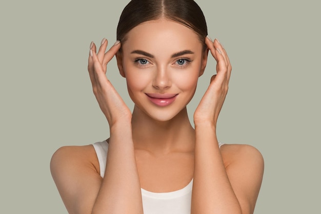 Schoonheid gezonde huid vrouwen aanraken van gezicht cosmetische studio portret. Sportkleding kleur achtergrond groen