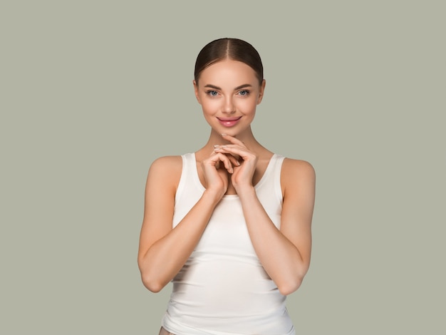 Schoonheid gezonde huid vrouwen aanraken van gezicht cosmetische studio portret. Sportkleding kleur achtergrond groen