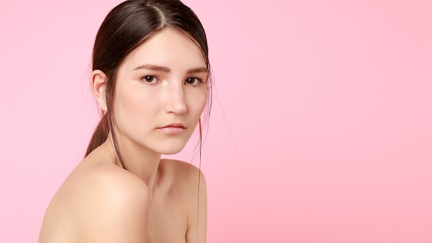 Schoonheid, huidverzorging en mensen concept - schoonheid fashion model meisje natuurlijke make-up met schattige glimlach op roze achtergrond. 16:9 panoramisch formaat.