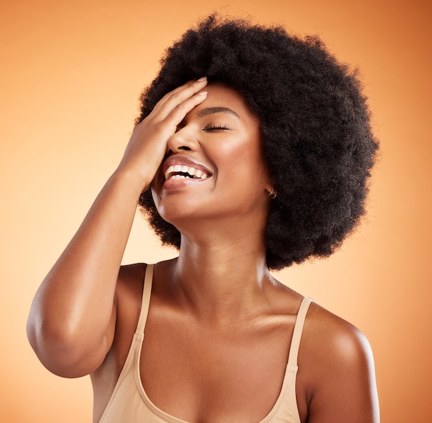 Schoonheid huidverzorging en zwarte vrouw met afro haar gezicht aanraken met make-up cosmetica en lachen terwijl blij met cosmetologie behandeling Afrikaans vrouwelijk model tegen bruine achtergrond voor dermatologie
