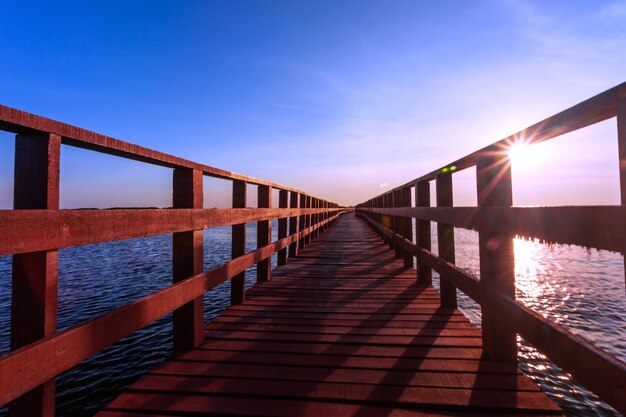 Schoonheid in de natuur rode brug lange weg en zonlicht in ochtendlandschap