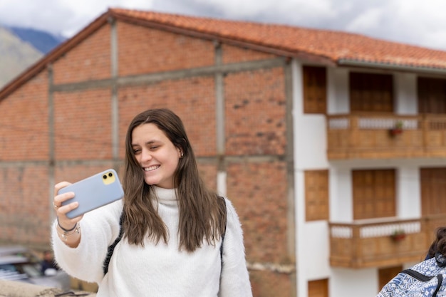 Schoonheid jonge latina vrouw die een selfie neemt voor een traditioneel huis