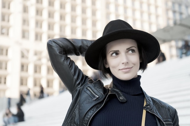 Schoonheid look make-up vrouw in zwarte hoed glimlach op trappen in Parijs Frankrijk mode Mode accessoire stijl sensuele vrouw met donkerbruin haar kapsel Huidverzorging jeugd gelaat