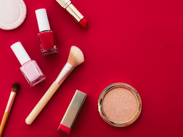 Schoonheid make-up en cosmetica flatlay ontwerp met copyspace cosmetische producten en make-up tools op rode achtergrond girly en vrouwelijk stijlconcept