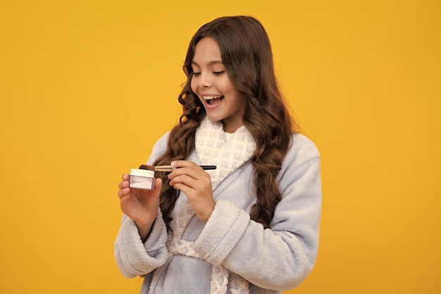 Schoonheid make-up en kinderen cosmetica tiener meisje jaren oud met penseel het aanbrengen van roodheid op het gezicht geïsoleerd