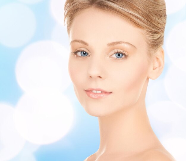 schoonheid, mensen en gezondheidsconcept - mooi jong vrouwengezicht over blauwe lichtenachtergrond