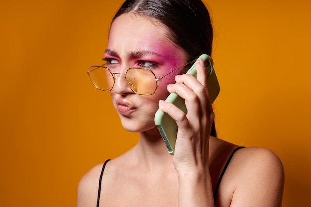 Schoonheid mode vrouw met bril heldere make-up poseren zwarte trui praten aan de telefoon bijgesneden weergave ongewijzigd