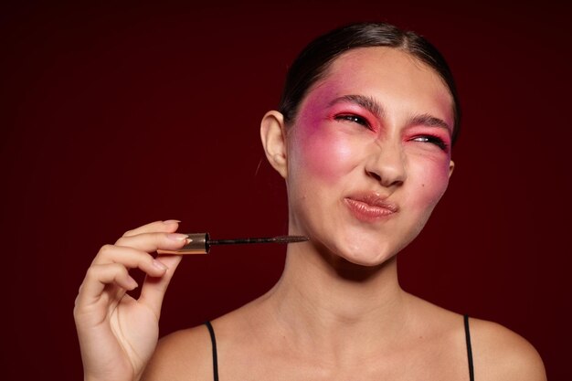 Schoonheid mode vrouwelijke make-up emoties cosmetica haarverzorging mascara roze achtergrond ongewijzigd