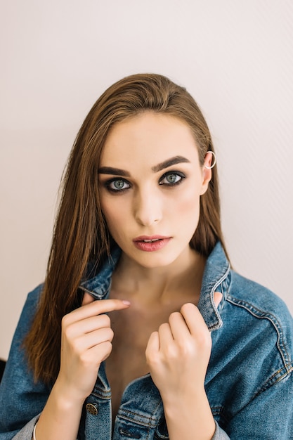 Schoonheid portret van meisje draagt denim jasje, smokey eyes, perfecte huidskleur