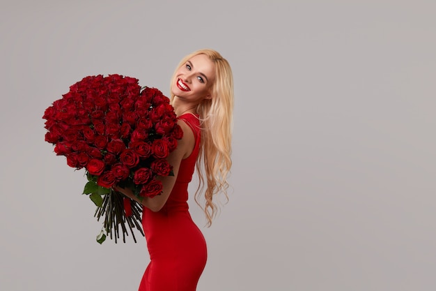 Schoonheid romantische vrouw met boeket van rode rozenbloemen. Rode lippen. Valentijnsdag