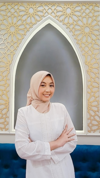 Foto schoonheid van indonesië vrouw met hijab vrolijke glimlach uitdrukking armen gekruist met islamitische ornamenten