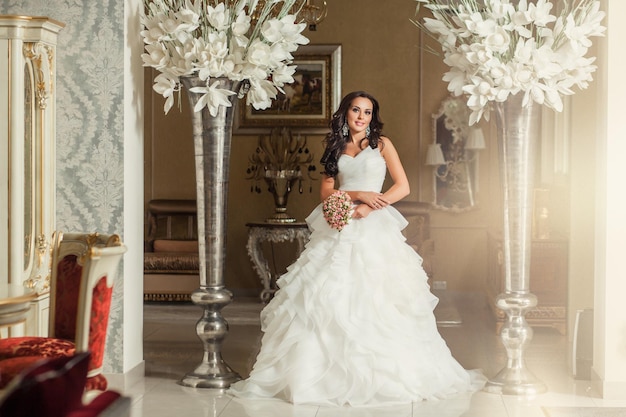 Schoonheid volwassen vrouw bruid in witte trouwjurk in luxe place