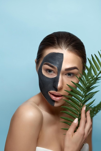 Schoonheid Vrouw Gezicht Huidverzorgingsmasker Portret van een mooie vrouw met een zwart masker van klei op het gezicht