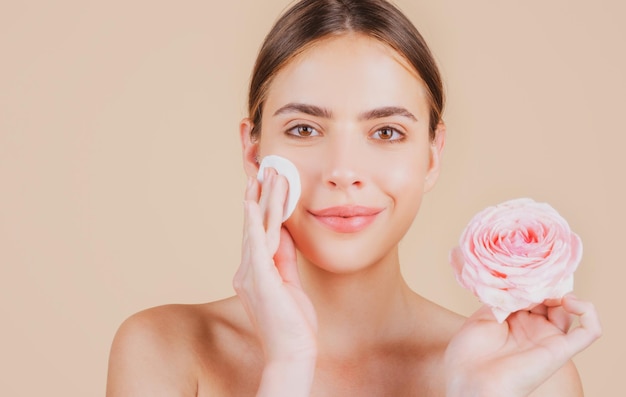 Schoonheid vrouw gezicht met natuurlijke make-up en roze bloemen verse schoonheid model jonge spa Mooie vrouwelijke wellness cosmetica Spa en wellness huidverzorging concept Gezichtsbehandeling