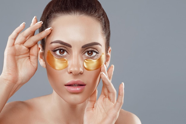 Schoonheid vrouw gezicht met onder de ogen collageen gouden pads Anti-aging hydraterende oogmasker gouden patches