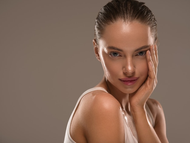 Schoonheid vrouw met handen gezonde natuurlijke make-up schone frisse huid concept kleur achtergrond