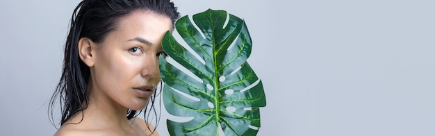 Foto schoonheid vrouw met natuurlijk groen palmbladportret mode schoonheid make-up cosmetica