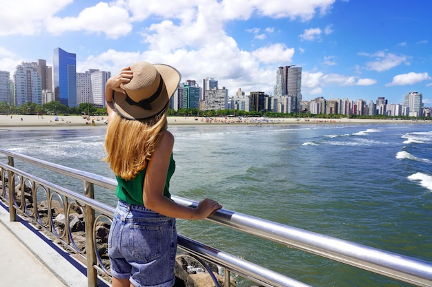 Schoonheid vrouwelijk model genieten van de skyline van moderne wolkenkrabbers aan de oceaankust