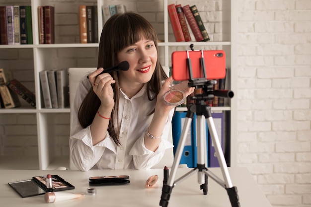 Schoonheid vrouwelijke vlogger met cosmetica