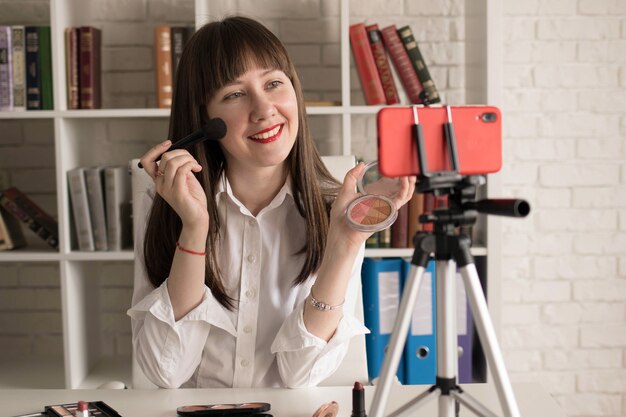 Schoonheid vrouwelijke vlogger met cosmetica