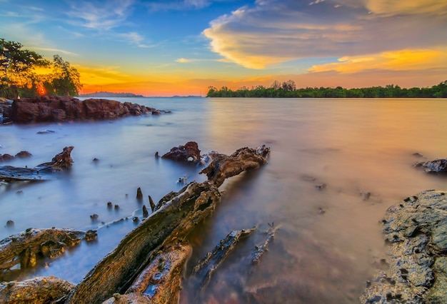 Schoonheid zonsondergang op het strand met koraal langs de kust Batam eiland