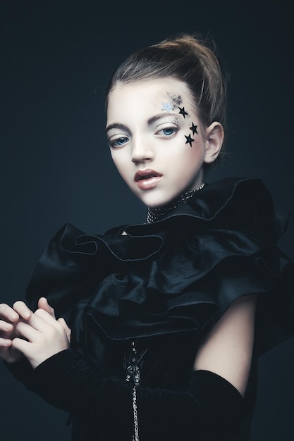 Schoonheids- en modeconcept Klein meisje met zwarte outfit Creatieve make-up