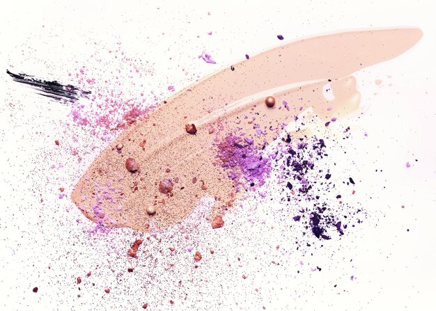 Schoonheidsconcept in violette kleuren. Vlekkerige make-up foundation, gebroken schaduwen en sparkles op witte achtergrond.