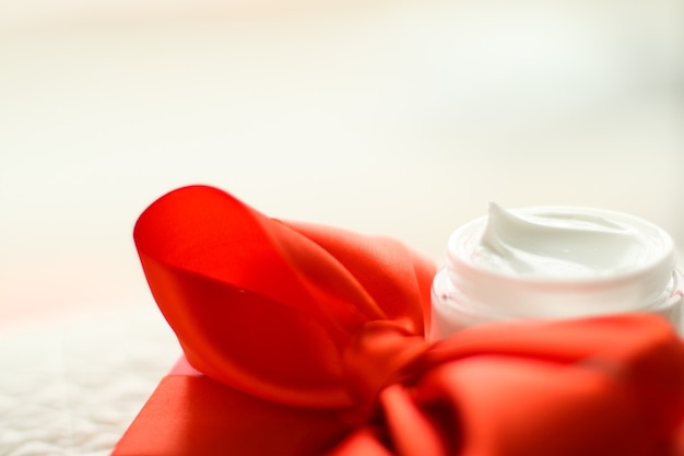 Schoonheidscosmetica en huidverzorgingsstijl concept luxe gezichtscrèmepot en rode geschenkdoos