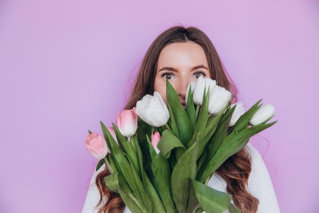 Schoonheidsmeisje die Lentetulpen houden Bloemboeket en glimlachen. Valentijnsdag. Moederdag.